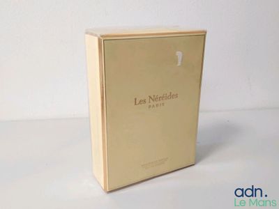une photo d'un coffret de parfum posé sur une table blanche