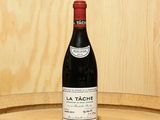 a bottle of wine sitting on top of a barrel