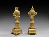 une paire de vases anciens en laiton sur socles, sur fond gris