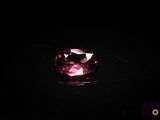 a close up of a pink gems stone on a black surface