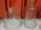 two empty glass bottles sitting on a white table