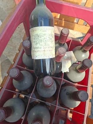 bottles of wine are in a red crate on a table