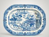 a blue and white platter with a landscape scene on it