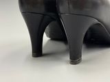 pair of black leather high heeled shoes on a white surface