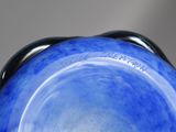 a blue vase with a black handle on a table