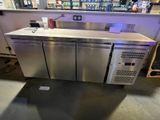 a stainless steel counter in a store with a lot of bottles on it