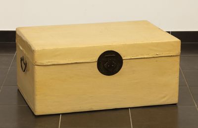 a wooden box on the floor with a black handle