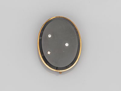 un gros plan sur une broche noire et dorée sertie de diamants