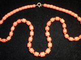 un gros plan d'un collier composé de perles orange sur un fond noir