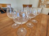 plusieurs verres à vin vides posés sur une table en bois dans une pièce