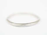 gros plan d'une bague en argent sur une surface blanche