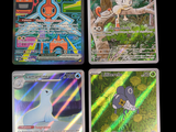 three pokemon cards are sitting on a table with a black background