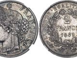 a silver coin with a woman ' s head and laurels on it