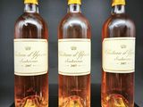 trois bouteilles de vin sont posées sur une table noire