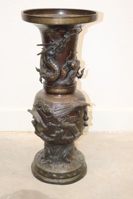 a bronze vase with a dragon on it sitting on a table