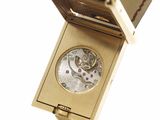 an image of a gold watch with a black leather case