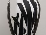 a black and white vase on a pedestal in a room