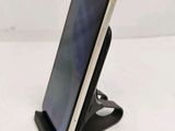 the phone is sitting on the stand on the white surface