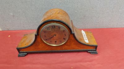 une petite horloge posée sur une table rouge