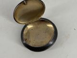 a small black and gold box on a white surface
