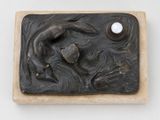 une sculpture représentant une femme tenant une perle dans la main