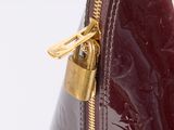 a close up of a red purse with a gold zipper