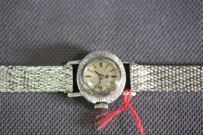 an image of a silver watch with a red string around it