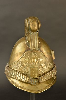 une image représentant un casque doré posé sur un socle, sur fond gris