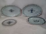 four pieces of blue and white porcelain dishes on a white surface