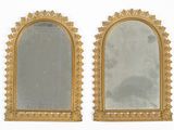 une paire de miroirs à cadre doré accrochés à un mur blanc, sur fond blanc