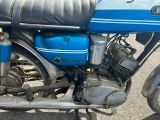 une moto bleue garée sur le bord de la route