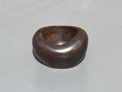 a wooden bowl sitting on a table with a white surface