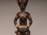 a bronze figurine of a woman holding a bowl