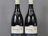 two bottles of wine sitting on top of a table next to each other