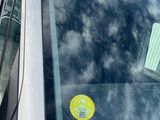 a sticker on the windshield of a car that is parked in a parking lot