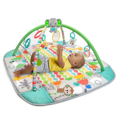Le bébé joue avec son jouet sur le tapis d'éveil.