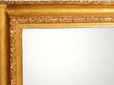an image of a gold framed mirror hanging on a wall