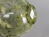 a glass bottle with a green substance inside of it