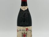 a bottle of red wine sitting on top of a white table