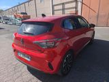 the rear end of a red car parked in a parking lot