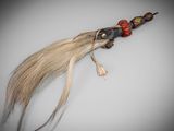 a long hair with beads on it on a white surface