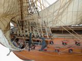 a wooden model of a sail boat on a stand