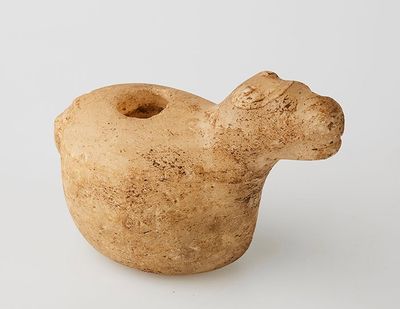 a small clay animal that is sitting on a white surface