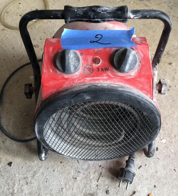a red and black heater sitting on the floor