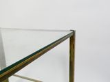 a glass and brass coffee table with a glass top