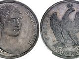 a close up of a coin with a bird on top of it