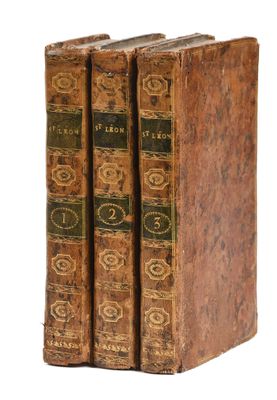 two old books sitting on top of each other on a white surface