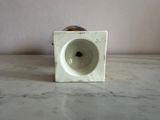 a white vase sitting on a marble counter top