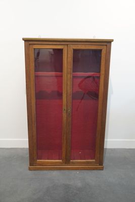 une image d'une armoire en bois avec des portes en verre
