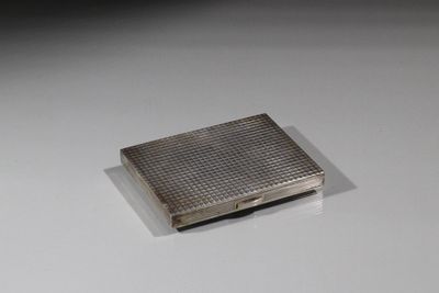 un petit étui à cigarettes en argent posé sur une table